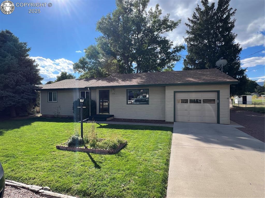 Caption: Single story home with concrete driveway, an attached garage, and a front yard