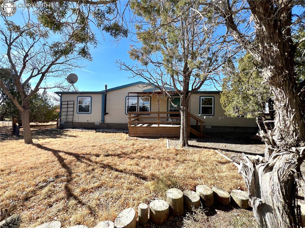 Caption: Manufactured / mobile home with a wooden deck, a front yard, and crawl space