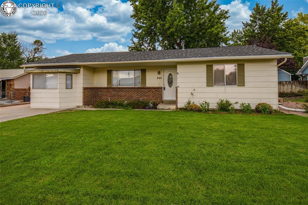 Caption: Expansive lawn, brick facade, white siding, dark roof, and mature trees