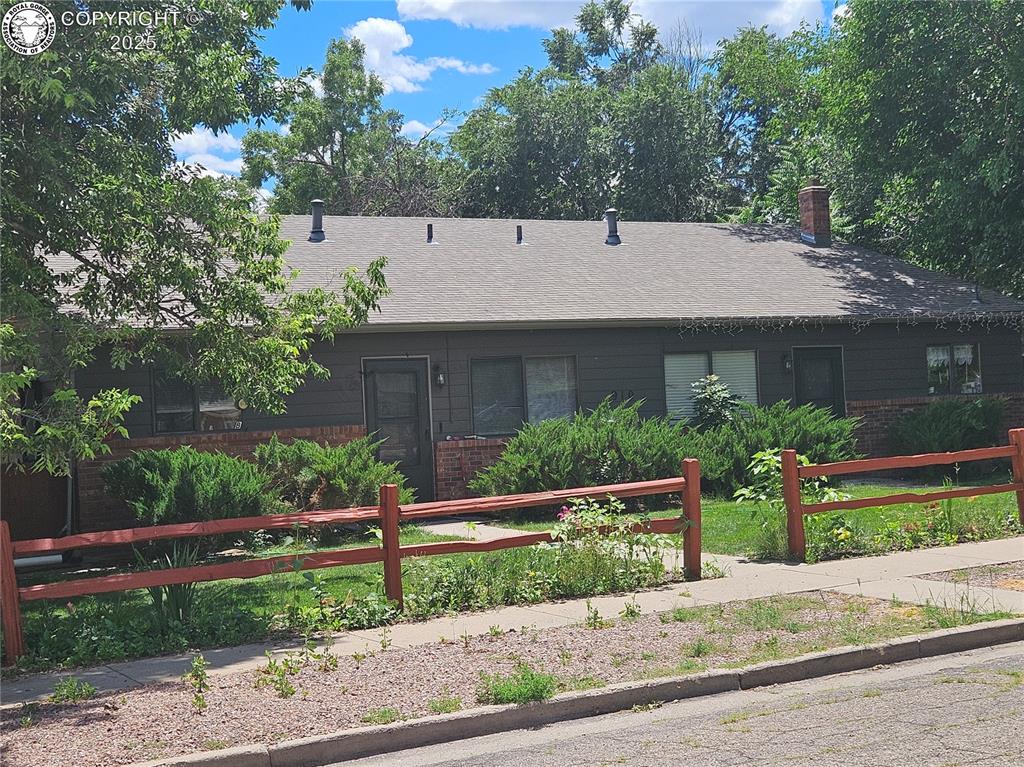 Caption: Ranch-style home featuring brick siding, a chimney, and roof with shingles