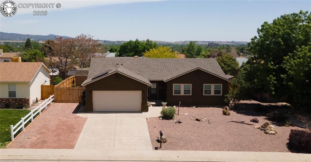 Caption: Single-story residence featuring a dark brown exterior siding, attached two-car garage, and a low-ma