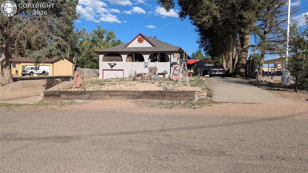 Caption: Stucco exterior with arched openings, gabled roofline, and attached garage