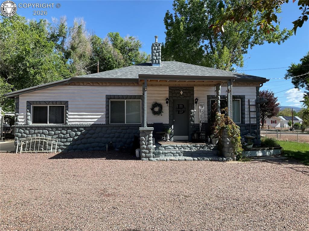 Caption: Ranch-style residence featuring a prominent front porch with stone-clad columns and steps, a stone-c