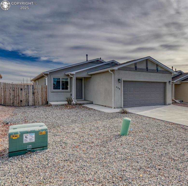 Caption: Ranch-style home featuring driveway, an attached garage, and stucco siding