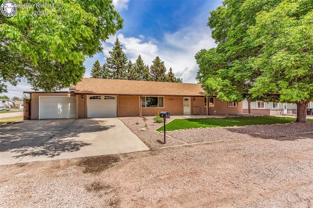 Caption: Ranch-style house with driveway, a garage, and stucco siding