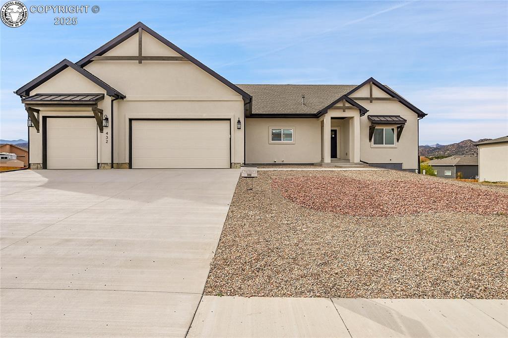 Caption: View of front of home featuring a garage, concrete driveway, stucco siding, roof with shingles, and 