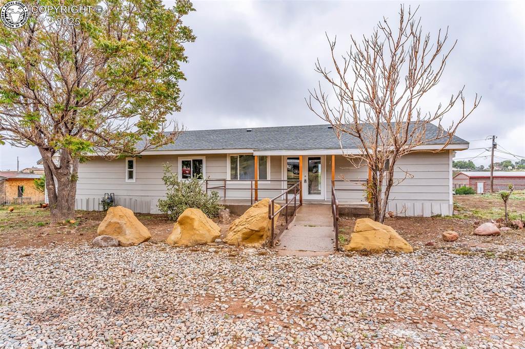 Caption: Single story home featuring covered porch and roof with shingles