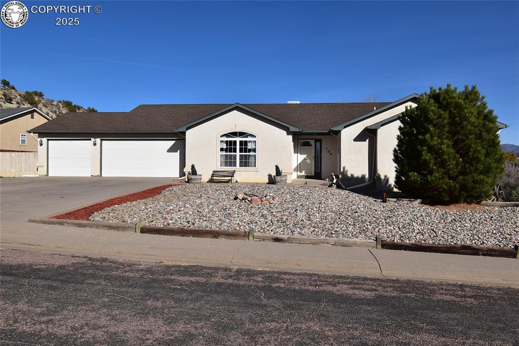 Caption: Ranch-style house featuring driveway, an attached garage, stucco siding, and a shingled roof