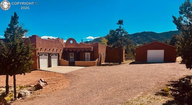 Caption: Southwestern Santa Fe-style residence featuring a stucco exterior, two-car garage with concrete driv