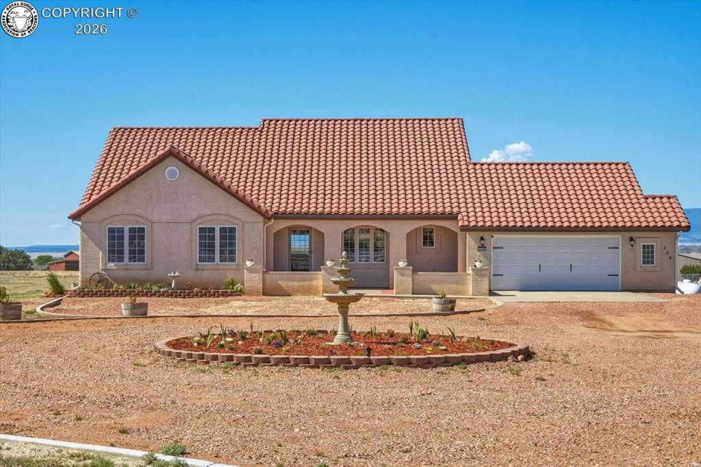 Caption: Attractive ranch-style home featuring a tile roof, front court yard, and circular driveway, all set 