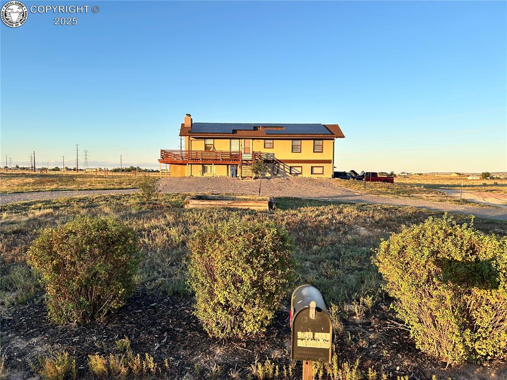 Caption:  solar panels, stairs, a chimney, and a rural view