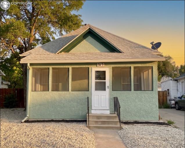 Caption: Stucco exterior with a peaked roofline and front gables