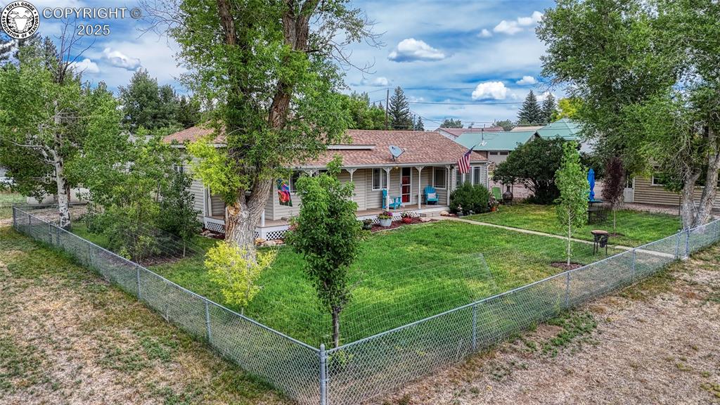 Caption: Bungalow-style home featuring a porch, a fenced backyard, and a shingled roof