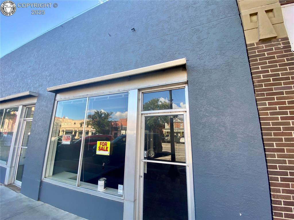 Caption: View of side of property with stucco siding and brick siding