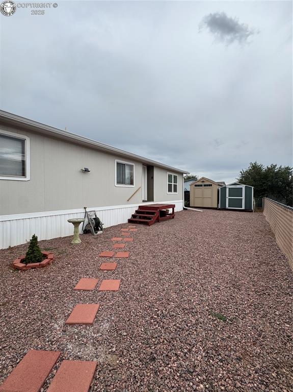 Caption: Rear view of house with a storage shed