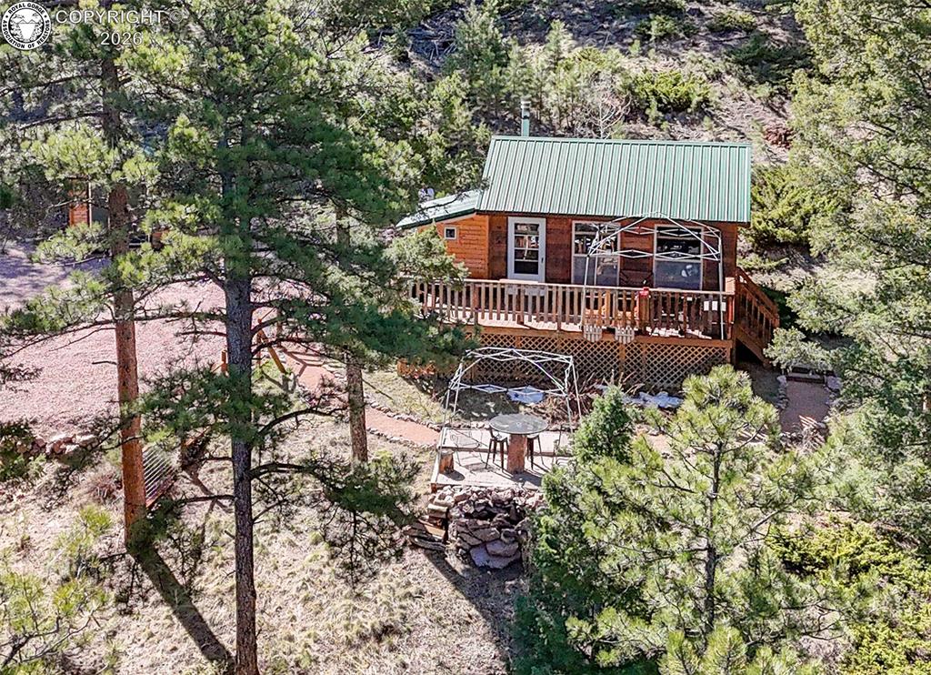 Caption: Rear view of property featuring a deck and a metal roof