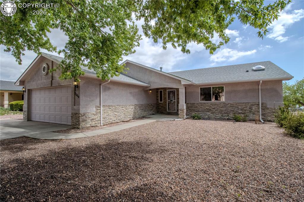 Caption: Single-story residence featuring a stucco exterior with a decorative stone facade, a two-car garage,