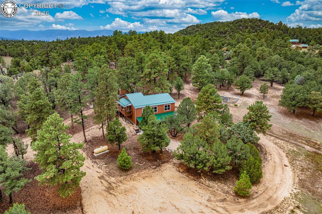Caption: Located on 5 acres, corner lot w/many trees AND usable