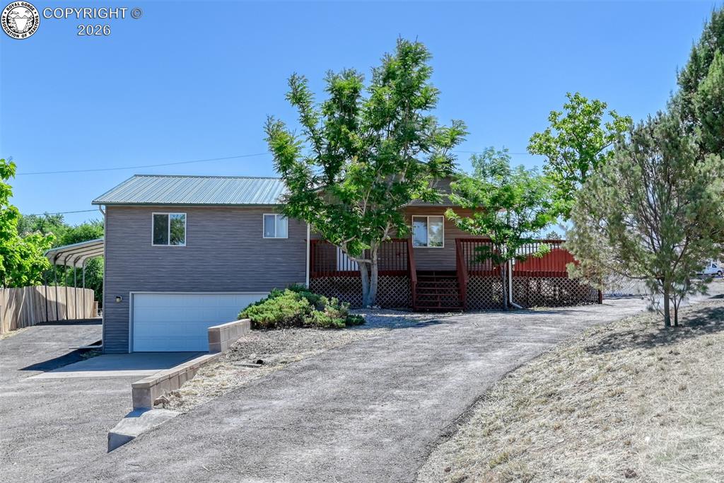 Caption: Two-story residential structure with a metal roof and attached garage