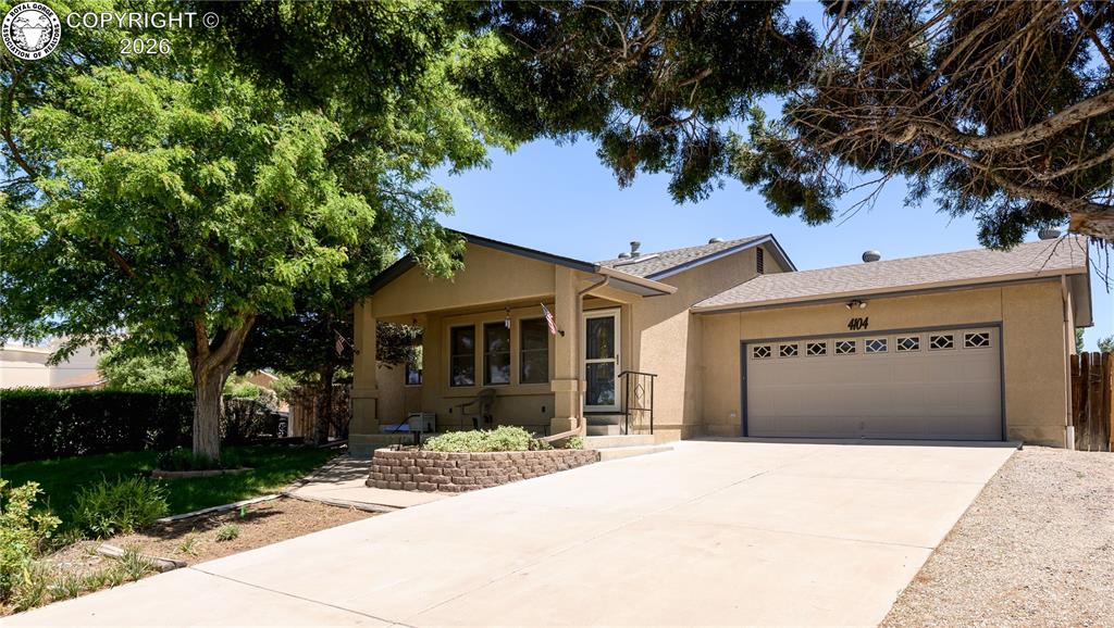Caption: Stucco exterior with a covered porch entry, a 2-car garage, and a concrete driveway
