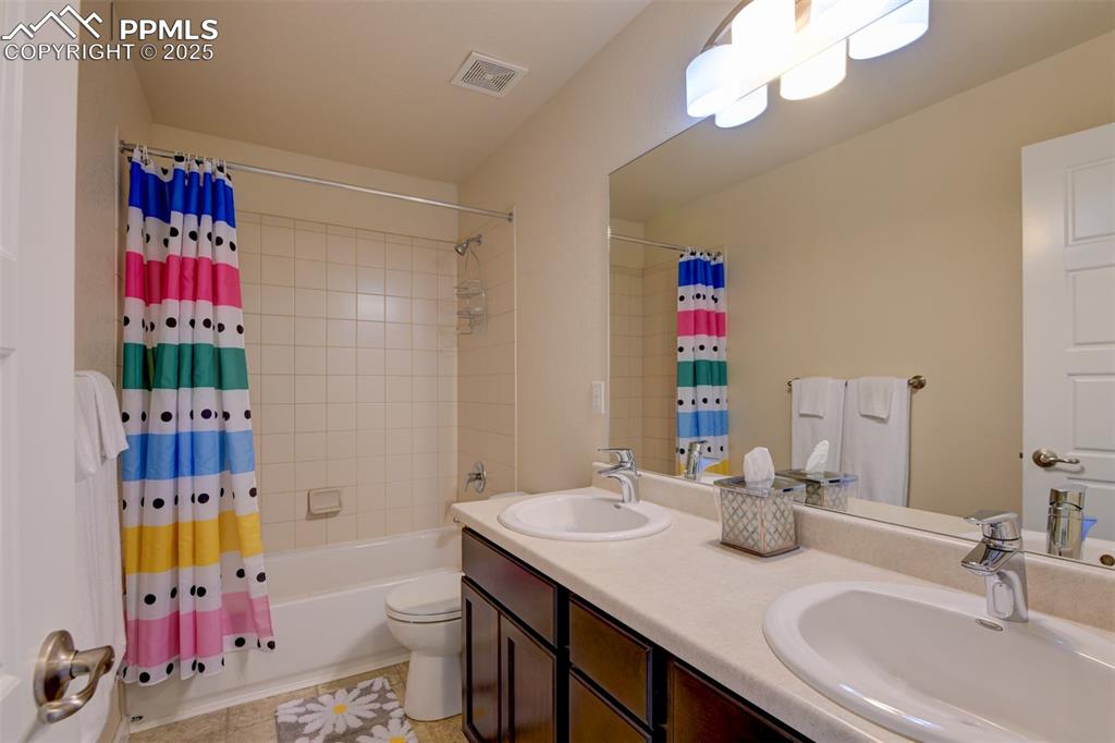 Image 33 of 45: Upper level main bath with dual sinks, tub/shower combo