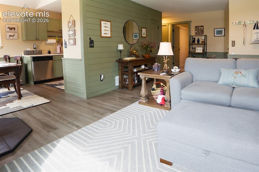 Image 13 of 46: Open-concept living area with wood-finish flooring, a dining area, and a ki