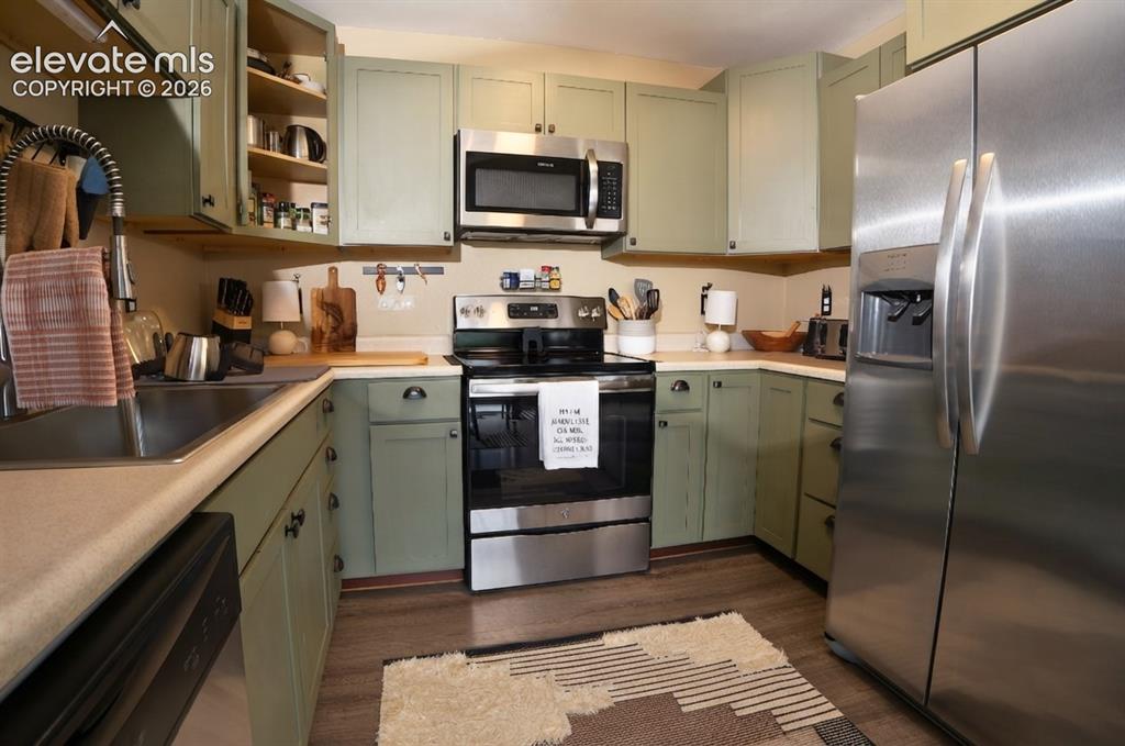 Image 15 of 46: Kitchen featuring green cabinetry, stainless steel appliances, a stainless
