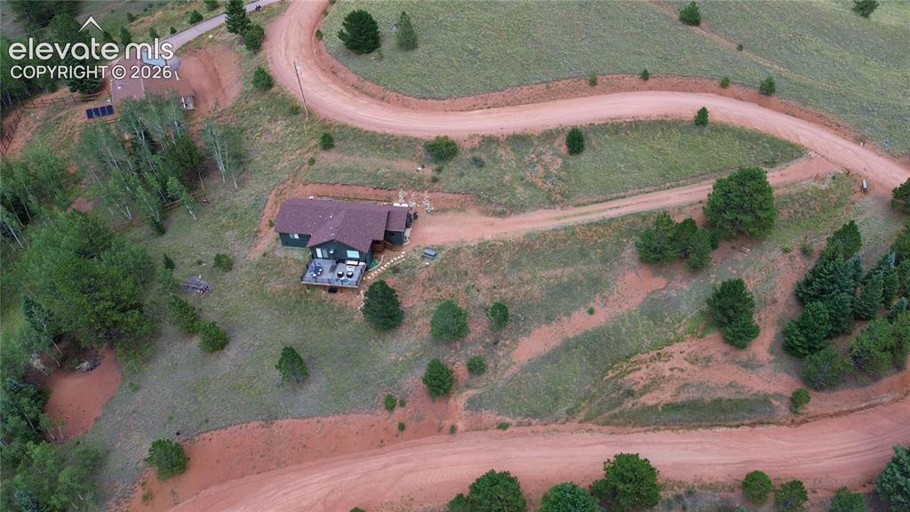 Image 29 of 46: Expansive property featuring a residence with a deck, multiple outbuildings