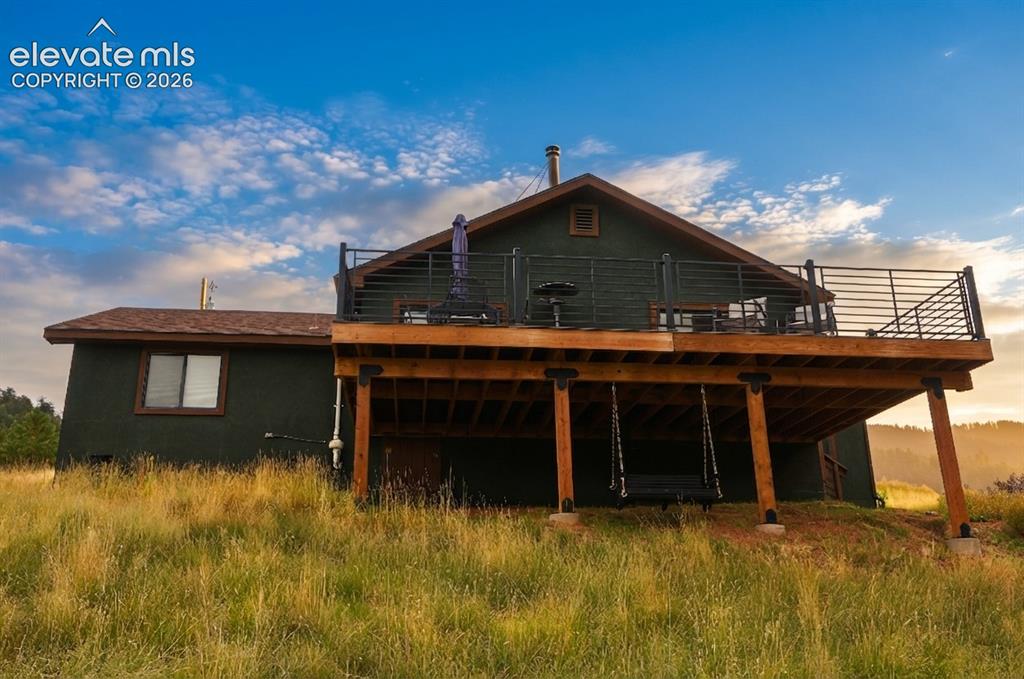 Image 33 of 46: Elevated wood deck with black metal railings, supported by substantial wood