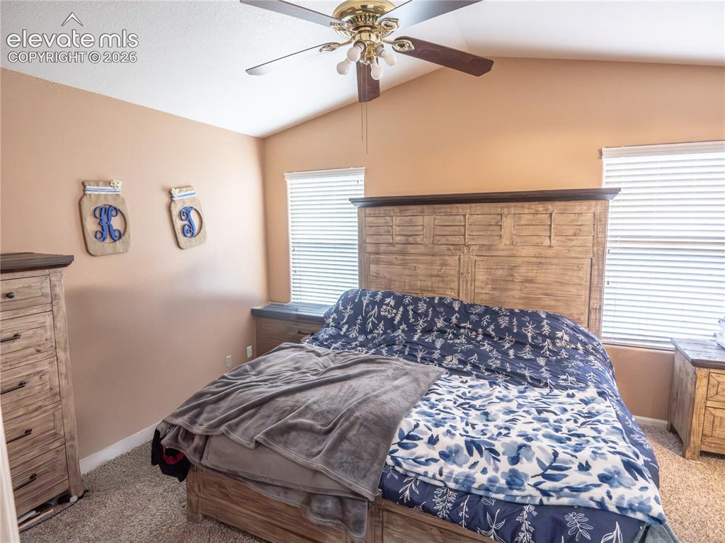 Image 11 of 13: Bedroom featuring a vaulted ceiling with a ceiling fan, wall-to-wall carpet
