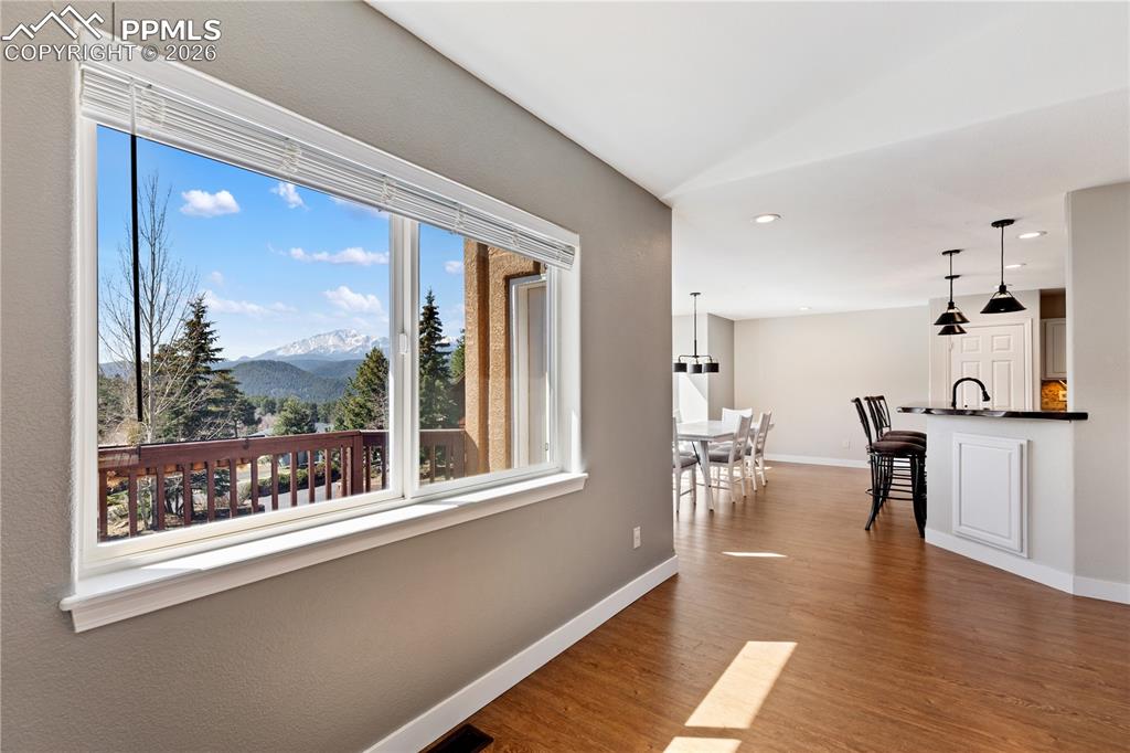 Image 11 of 29: Expansive window framing a mountain and tree-lined landscape