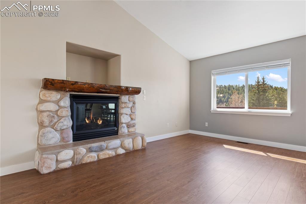 Image 12 of 29: Stone fireplace with a substantial wood mantel