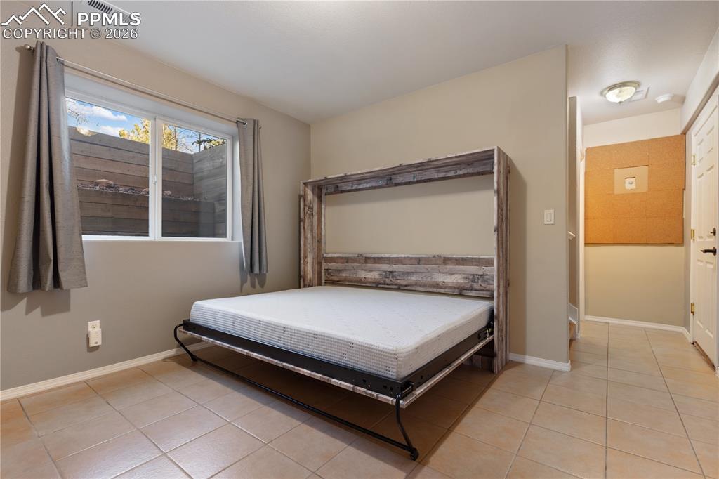 Image 19 of 29: Room featuring a built-in Murphy bed with a rustic wood-finish frame, tile 