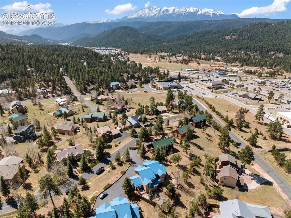 Image 30 of 33: Expansive mountain scenery featuring snow-capped peaks and evergreen forest
