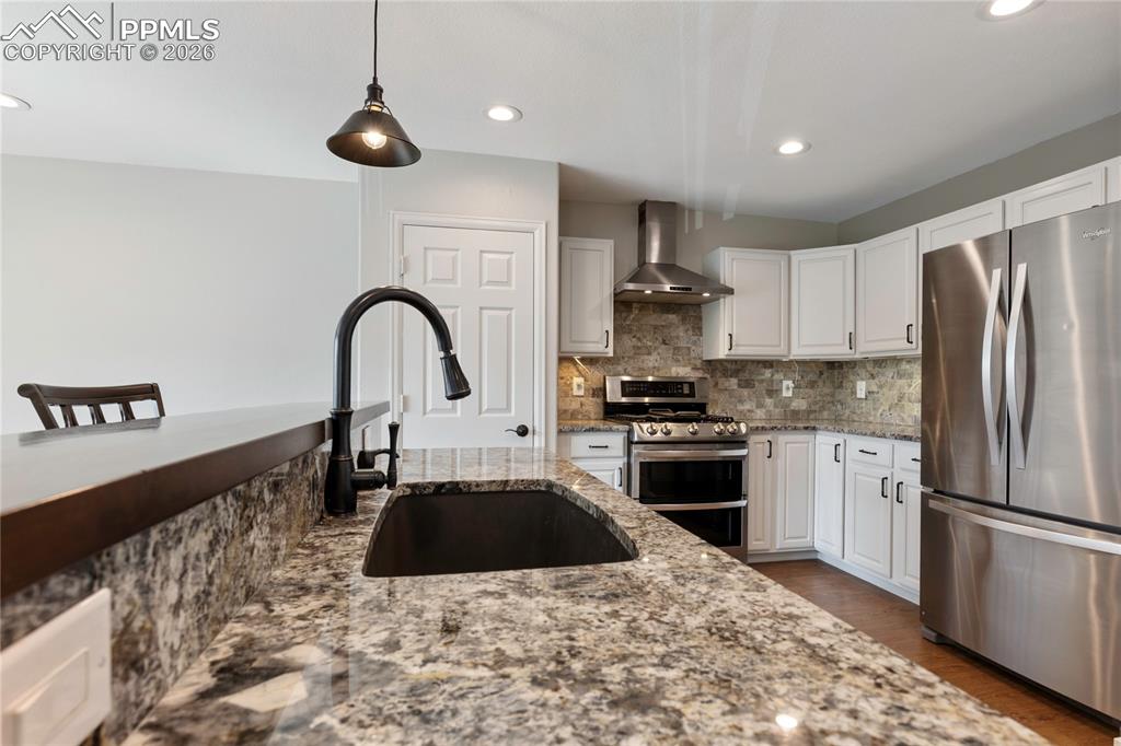 Image 4 of 29: Kitchen featuring granite countertops, stainless steel appliances, white ca