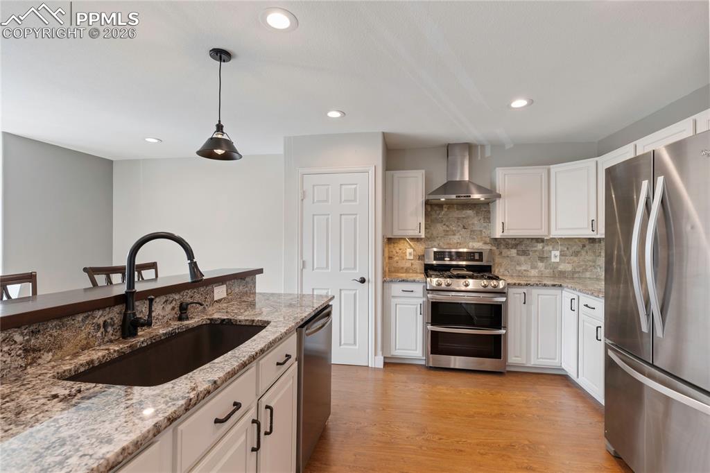 Image 5 of 29: Kitchen featuring a large island with an undermount sink, granite counterto