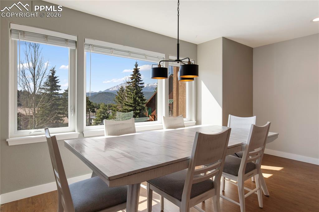 Image 9 of 29: Dining area featuring expansive windows, wood-finish flooring, a modern cha