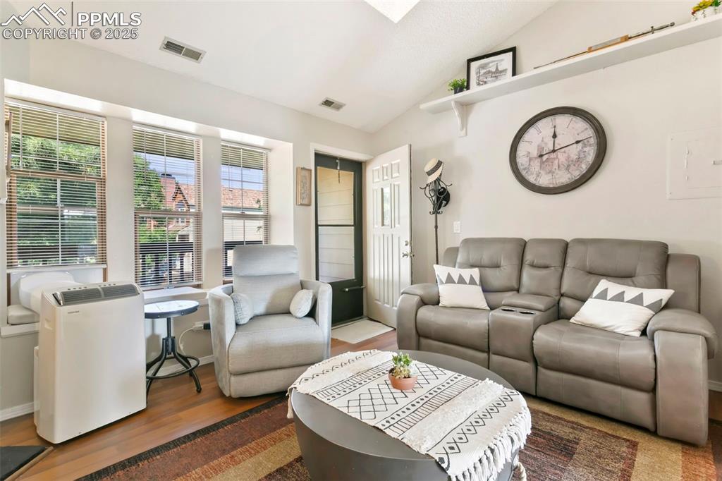 Image 11 of 17: Living room with vaulted ceiling and skylight