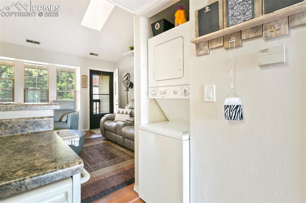 Image 8 of 17: Laundry space with a skylight & stackable washer and dryer