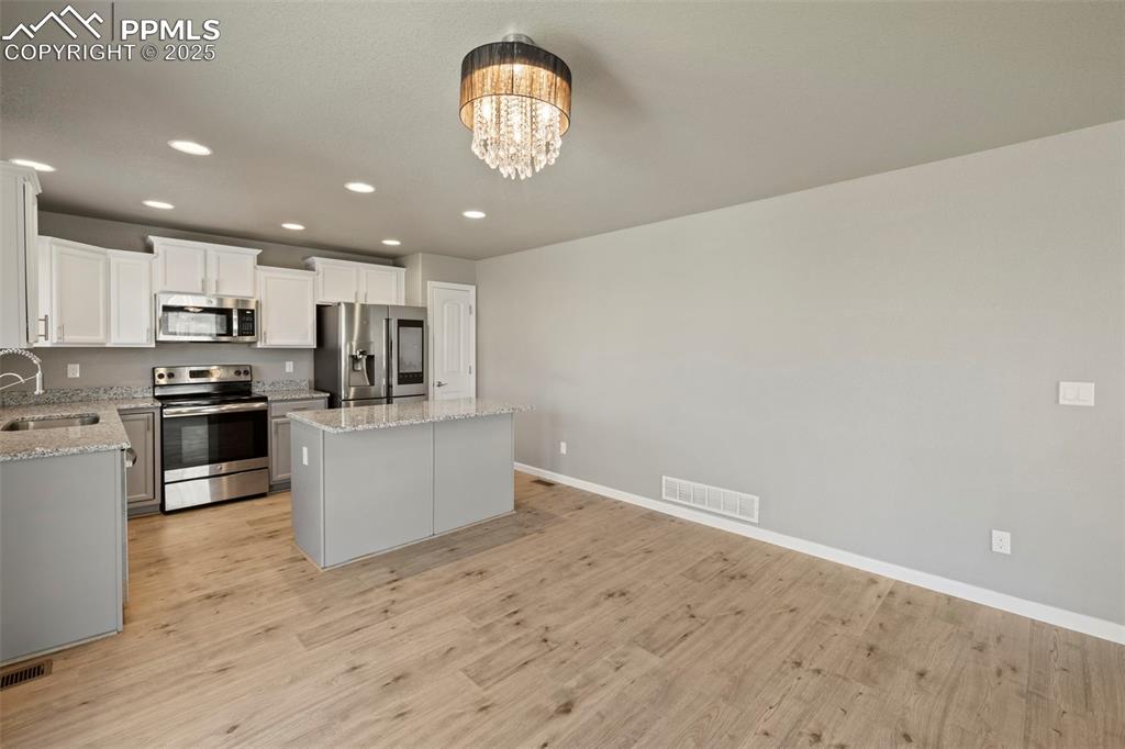 Image 11 of 35: well-appointed kitchen featuring granite countertops, a spacious center isl