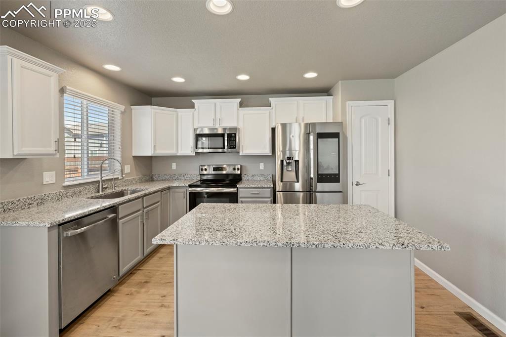 Image 13 of 35: well-appointed kitchen featuring granite countertops, a spacious center isl