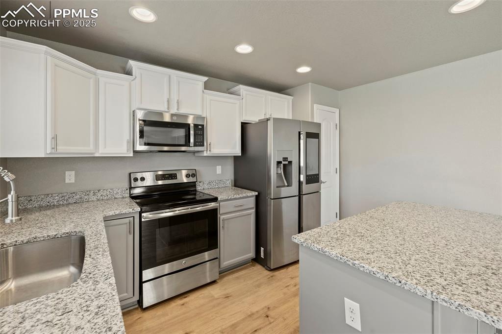 Image 15 of 35: well-appointed kitchen featuring granite countertops, a spacious center isl