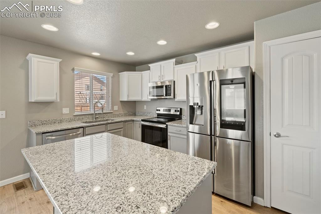 Image 18 of 35: well-appointed kitchen featuring granite countertops, a spacious center isl