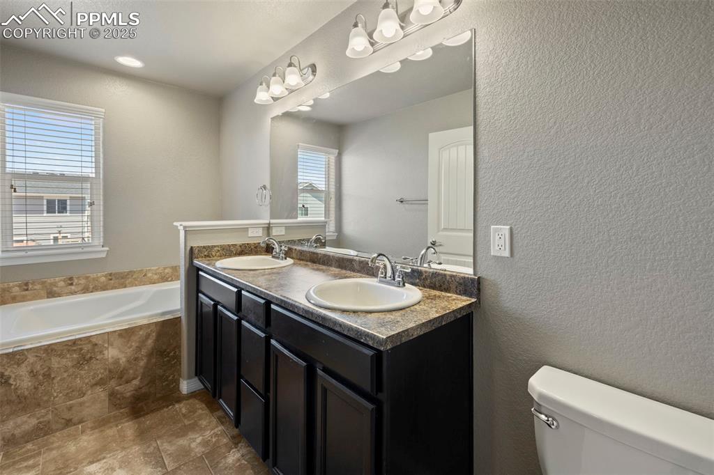 Image 21 of 35: The primary suite offers a luxurious 5-piece bathroom with granite counters