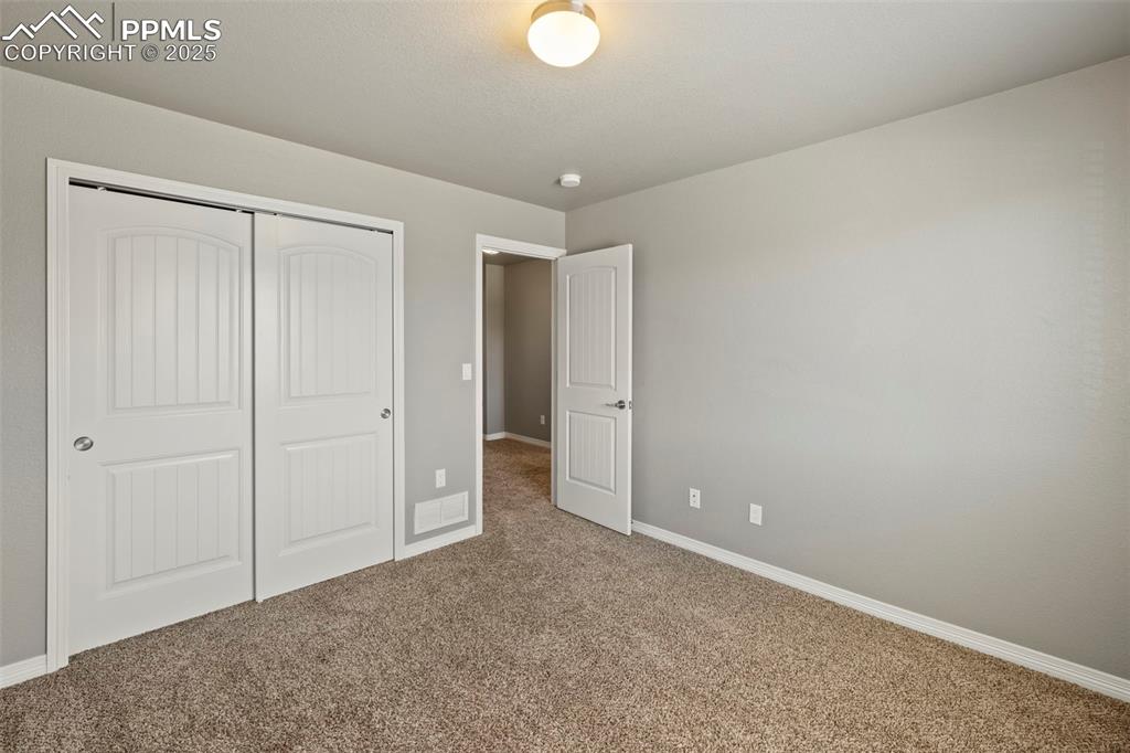 Image 25 of 35: Three additional bedrooms—two with carpet and one with a walk-in closet—sha