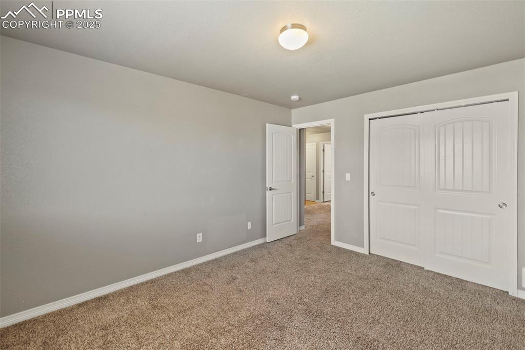 Image 26 of 35: Three additional bedrooms—two with carpet and one with a walk-in closet—sha