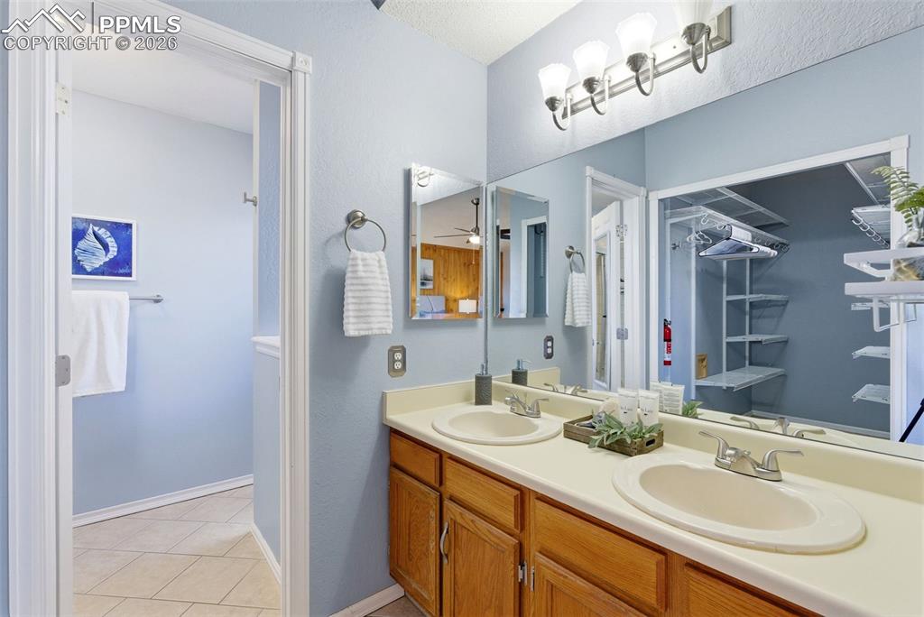 Image 17 of 45: Full bath with double vanity and light tile patterned flooring