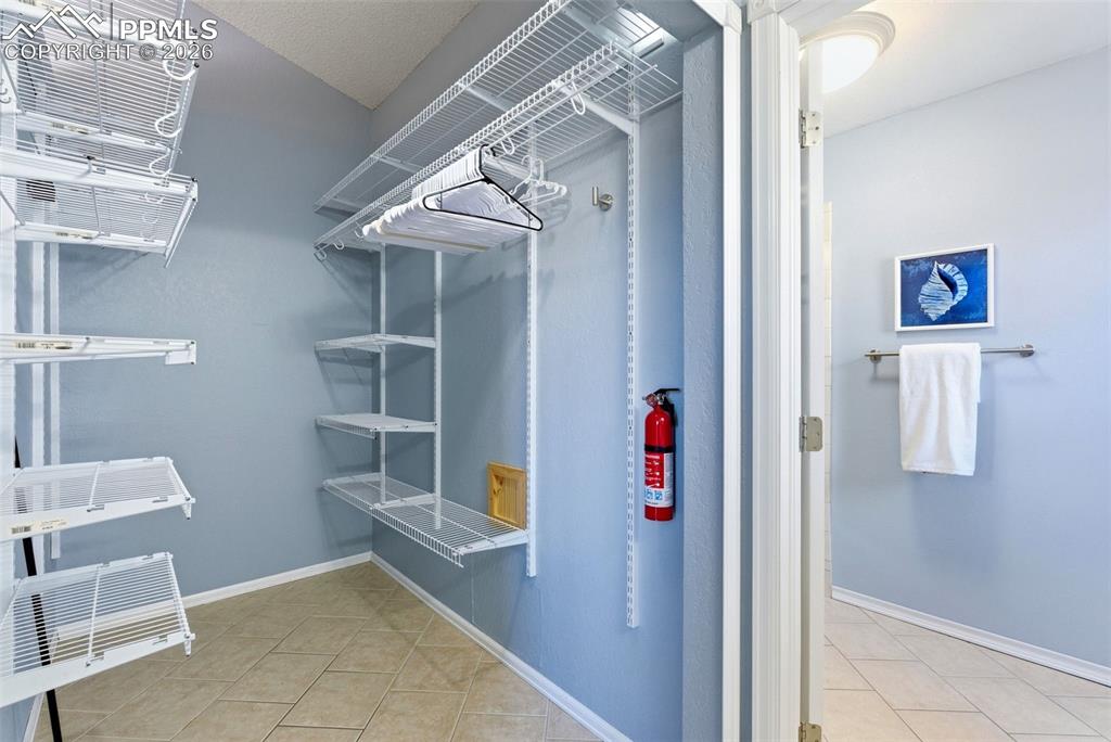 Image 18 of 45: Walk in closet featuring light tile patterned flooring