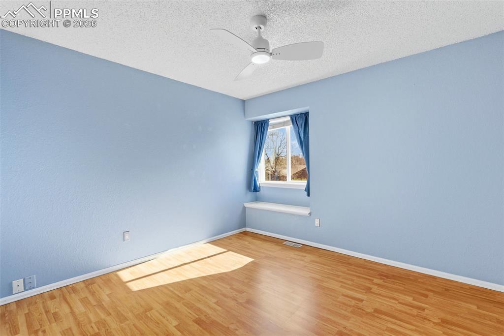 Image 21 of 45: Spare room featuring wood finished floors, a textured ceiling, and a ceilin