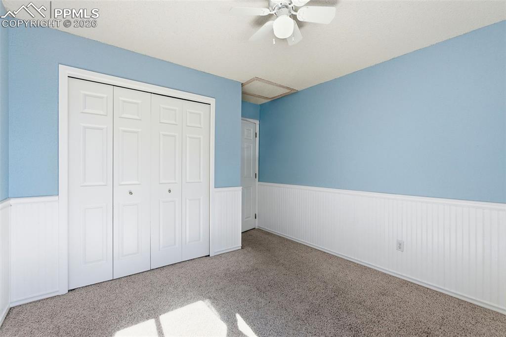 Image 26 of 45: Unfurnished bedroom with a wainscoted wall, a closet, carpet floors, and a